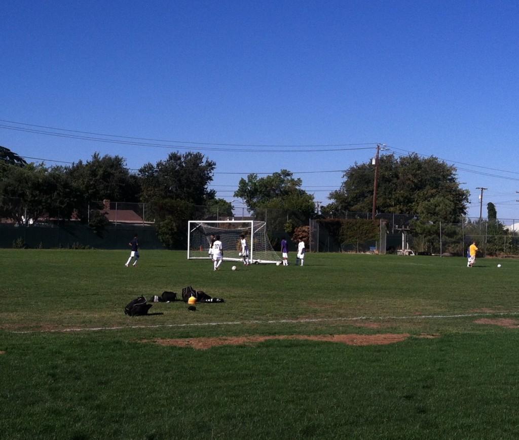 The boys soccer team runs on the field during practice.