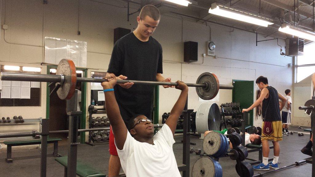 Jonathan Georgia lifts weights with spotter Devin Foster.