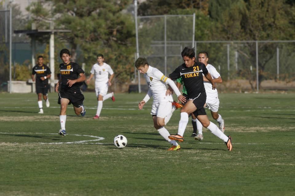 Jacob Gonzalez is running to get to the ball before the Tokay player.