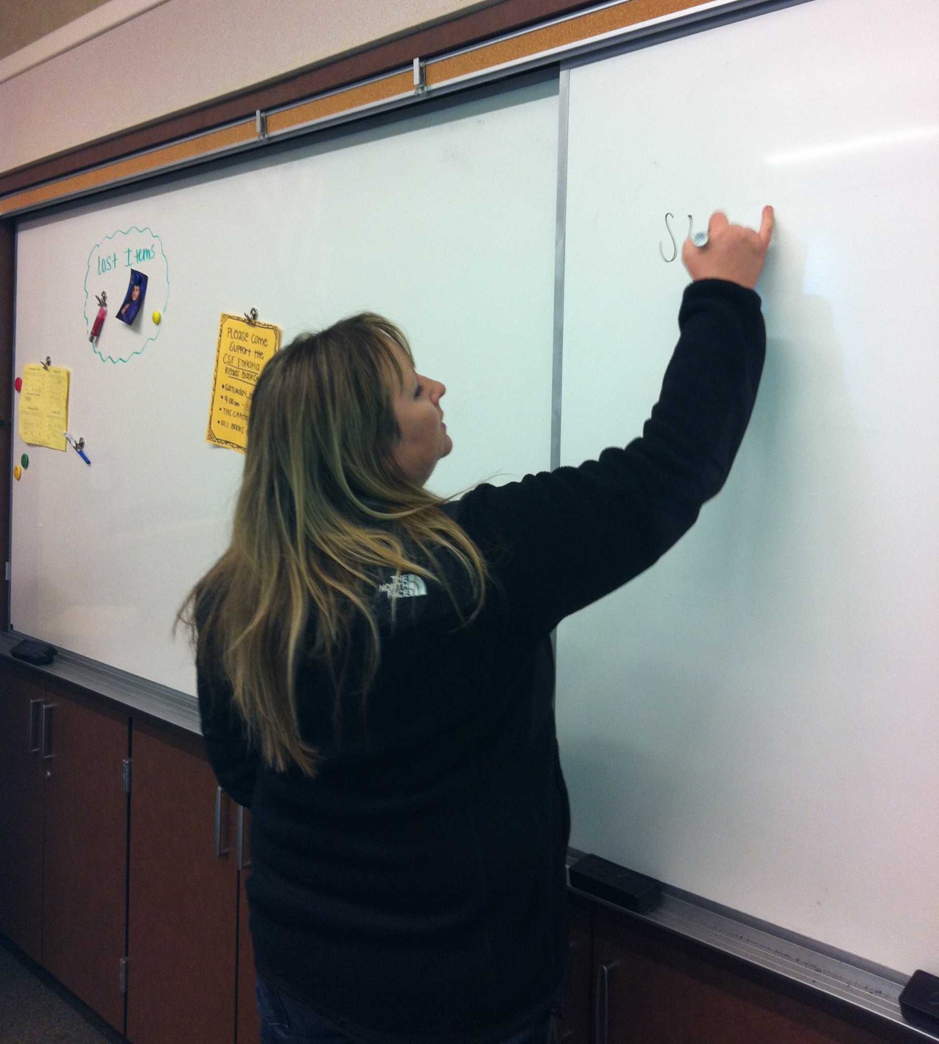 Ms. Castello writing a lesson down on the board. 