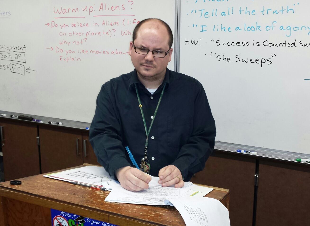 English teacher Brian Musich marks up a poem by Emily Dickinson.