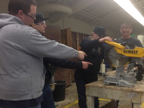 Mr. Gentry helps Drew Davis (junior), Jacob Dutra (junior), and Andrew Maroulas (freshman) cut a piece of wood.