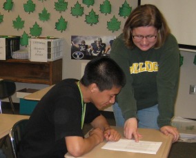 Mrs. Lee helps a student with his class work.
