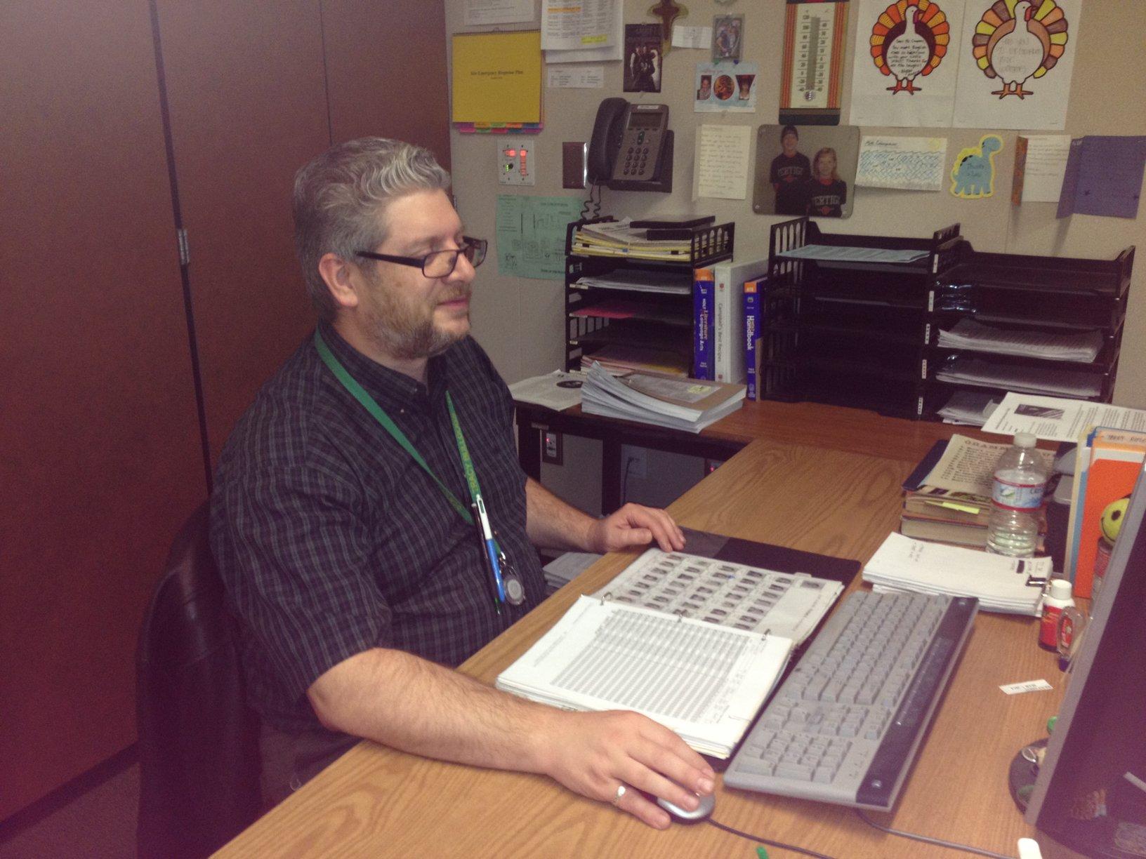 English teacher Curtis Campbell grades assignments during passing period.