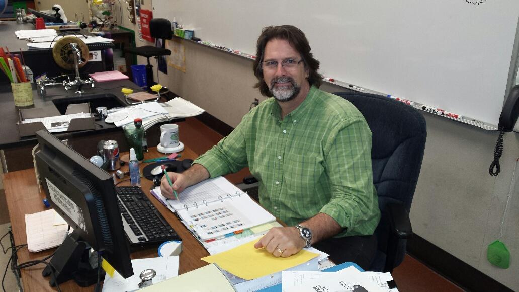 Science teacher Ken Wedel grades papers during lunch.