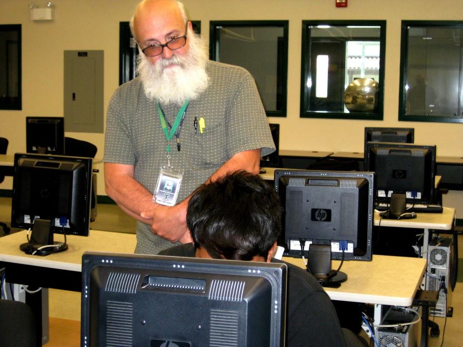  Larry Mendonca helps student with a computer assignment in Electronics.