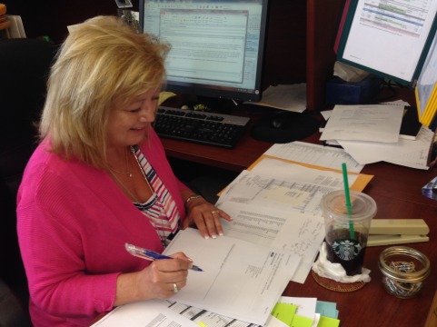IB Coordinator Terri Sorgent looks over papers at her desk.