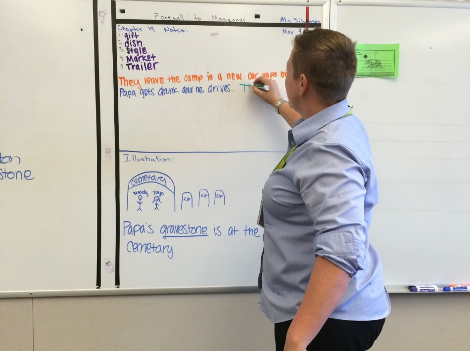 Silvinson prepares a lesson on the white board for her students.