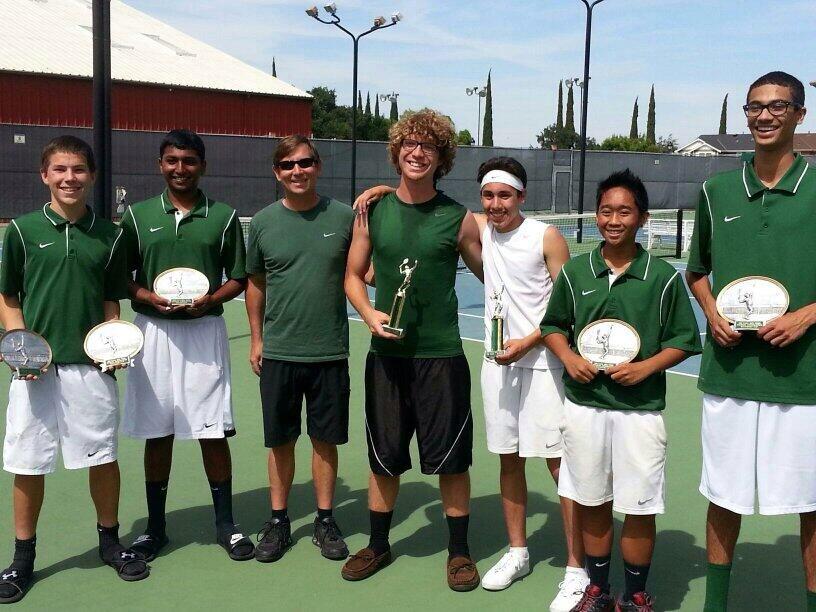 Members of the tennis team stand proud with awards after their league finish. 