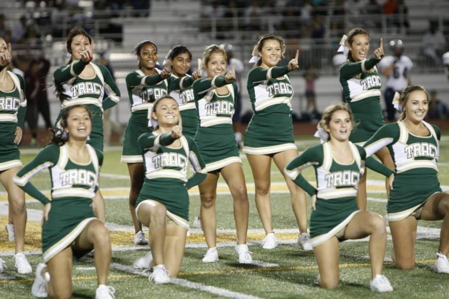 Girls cheer team performs at first home football game. 