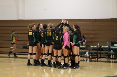 Tracy High Varsity Volleyball team huddles together after a strong play at a game vs. Kimball.