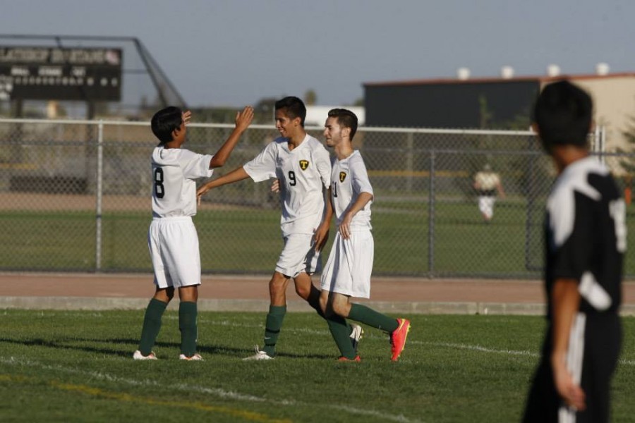 Soccer+team+players+high-five+each+other+in+excitement+after+a+scored+goal+in+a+game+against+Lathrop+High.