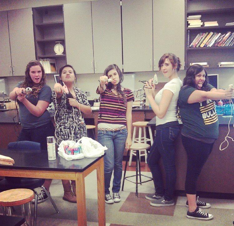 Earth Club members pose with glue guns while putting a project together. -Elizabeth McIntyre