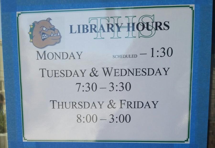 New library hours posted on doors to library