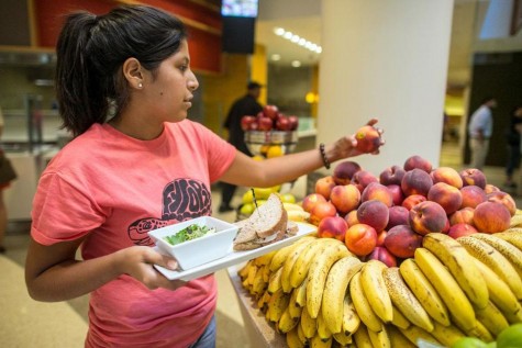 A student picking out a healthy nutritious lunch for herself.